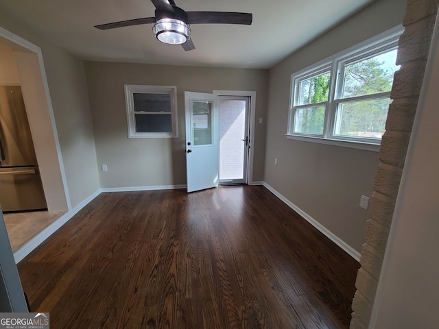 empty room with dark hardwood / wood-style floors and ceiling fan