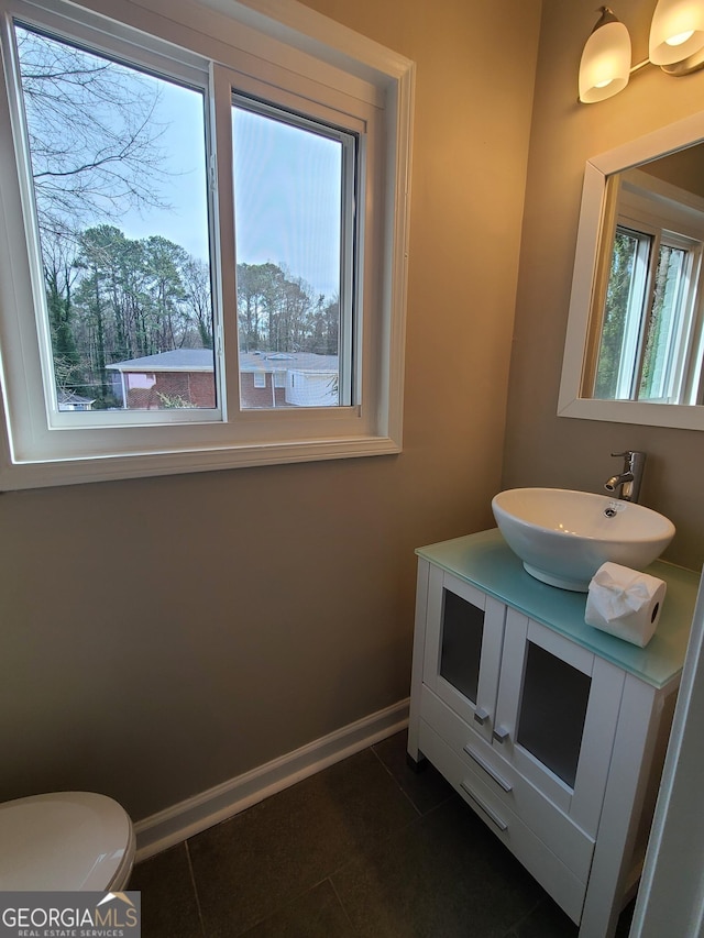 bathroom with tile patterned floors, toilet, vanity, and plenty of natural light