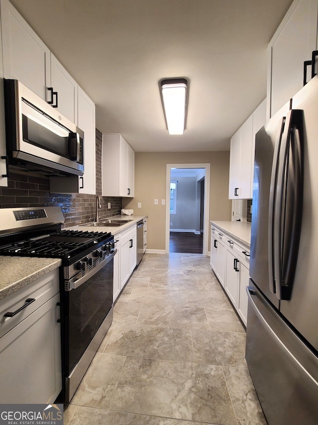 kitchen with white cabinetry, sink, backsplash, and stainless steel appliances