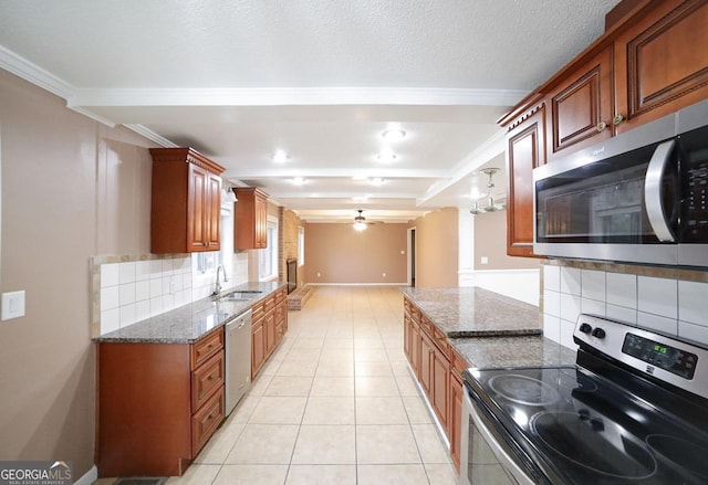 kitchen featuring tasteful backsplash, stainless steel appliances, sink, and dark stone counters