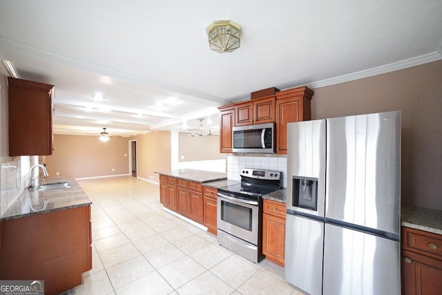 kitchen featuring sink, ceiling fan, stainless steel appliances, decorative columns, and decorative backsplash