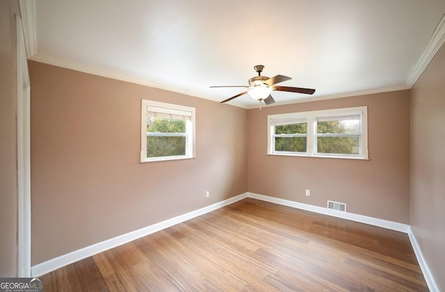 spare room with light hardwood / wood-style flooring, a wealth of natural light, ornamental molding, and ceiling fan