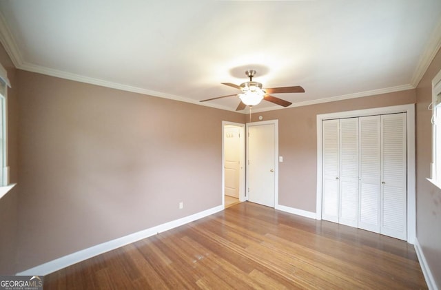 unfurnished bedroom featuring crown molding, ceiling fan, and light wood-type flooring