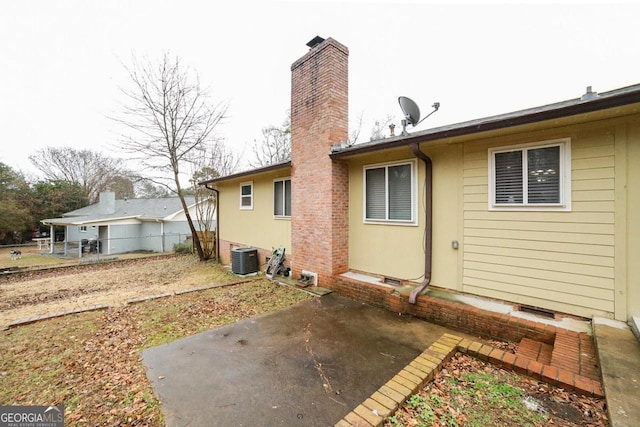 rear view of house with central AC and a patio area