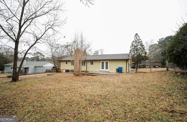 rear view of property with a patio, a yard, and french doors