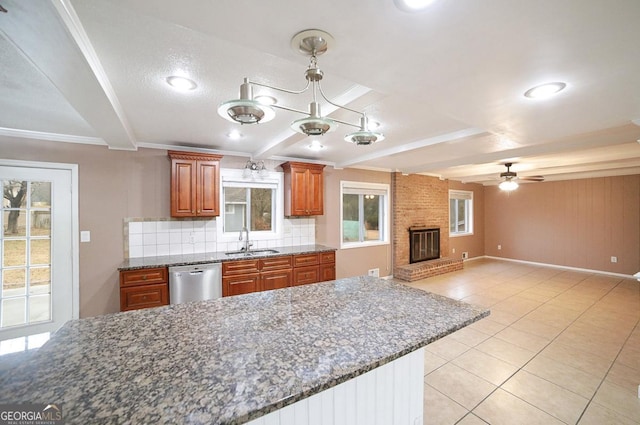 kitchen with sink, beam ceiling, a fireplace, decorative backsplash, and stainless steel dishwasher