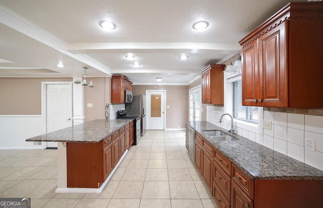 kitchen with a kitchen bar, sink, tasteful backsplash, appliances with stainless steel finishes, and dark stone counters