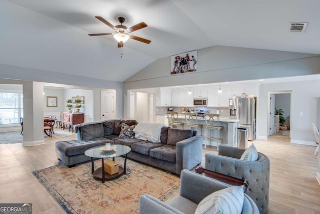 living room with vaulted ceiling, ceiling fan, and light hardwood / wood-style floors