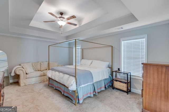 carpeted bedroom featuring crown molding, ceiling fan, and a tray ceiling