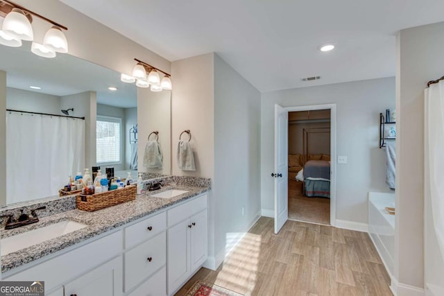 bathroom featuring a tub to relax in, vanity, and hardwood / wood-style floors