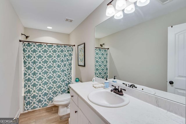 full bathroom with vanity, hardwood / wood-style flooring, shower / bath combo, and toilet