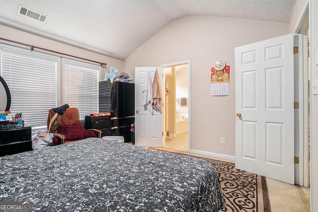 carpeted bedroom featuring lofted ceiling, ensuite bath, and a textured ceiling