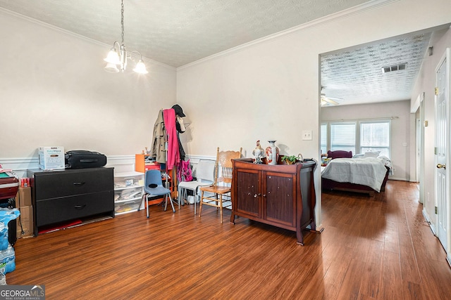 bedroom featuring dark hardwood / wood-style flooring, crown molding, a textured ceiling, and an inviting chandelier