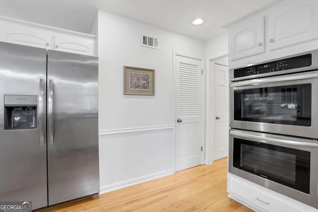 kitchen with white cabinetry, stainless steel appliances, and light wood-type flooring