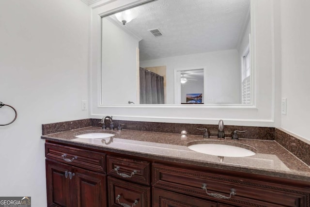 bathroom with vanity, ornamental molding, and a textured ceiling