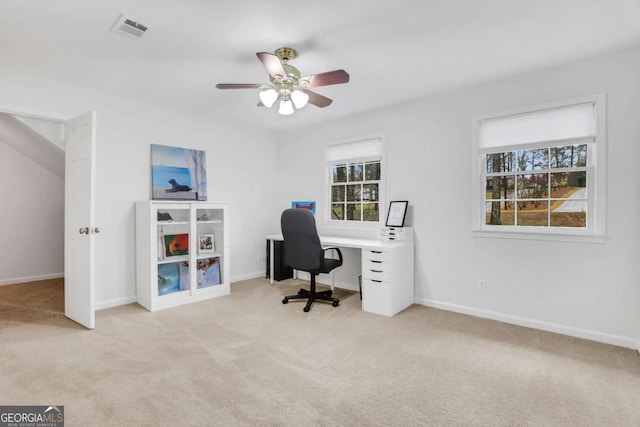 office space featuring ceiling fan, plenty of natural light, and light carpet