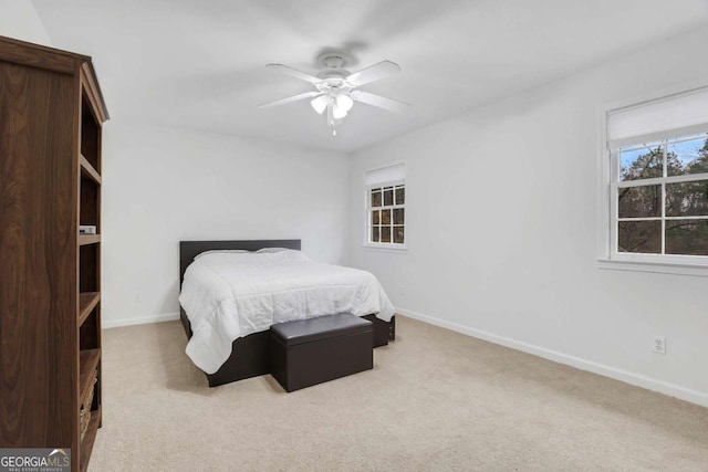 bedroom with ceiling fan and light carpet