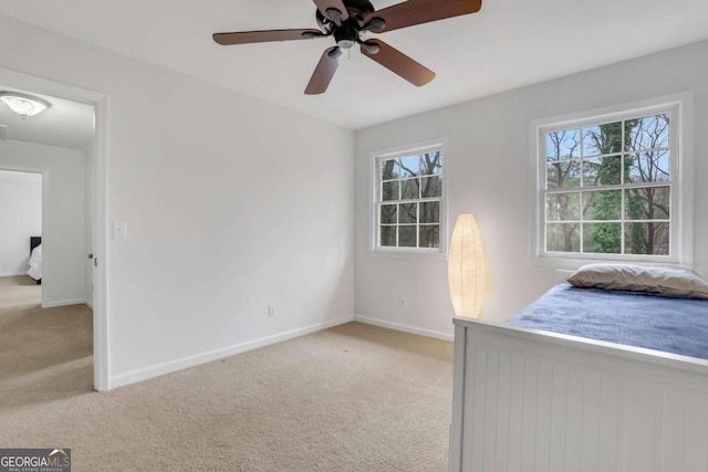 unfurnished bedroom with ceiling fan, light colored carpet, and multiple windows