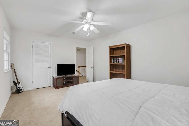 carpeted bedroom with ceiling fan and a closet