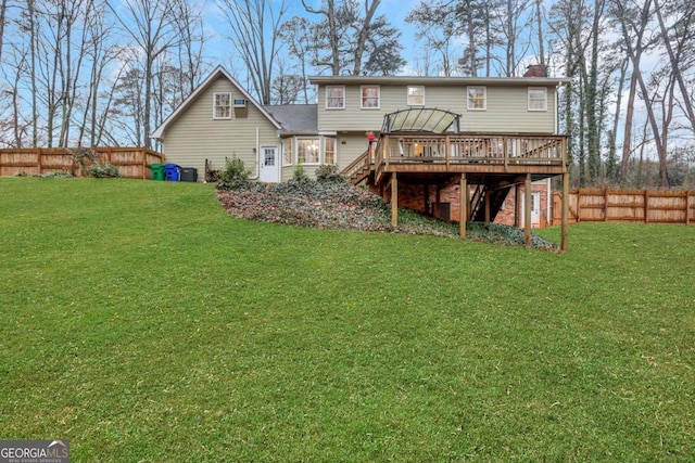 back of property with a deck and a lawn