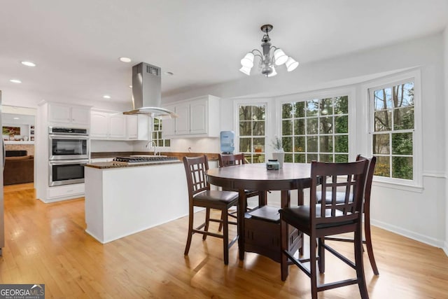 dining space with an inviting chandelier and light wood-type flooring