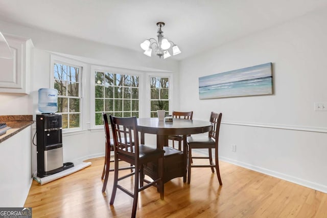 dining space with a notable chandelier and light wood-type flooring