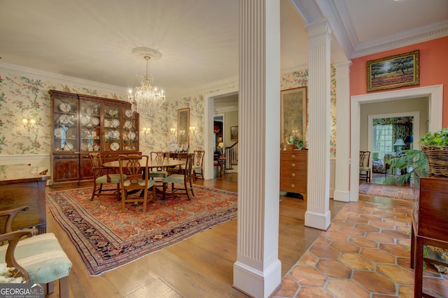 dining area with an inviting chandelier, light wood-type flooring, ornamental molding, and ornate columns