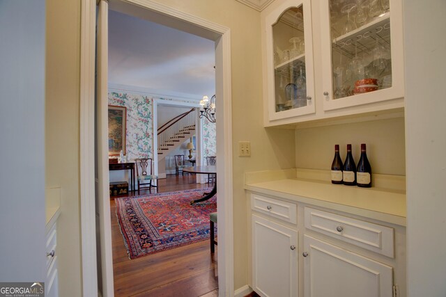 dining space featuring hardwood / wood-style flooring, ornamental molding, and a chandelier