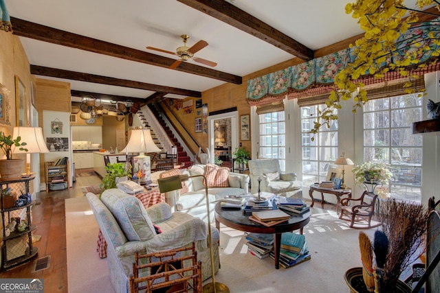 living room with ceiling fan, beam ceiling, and light hardwood / wood-style floors