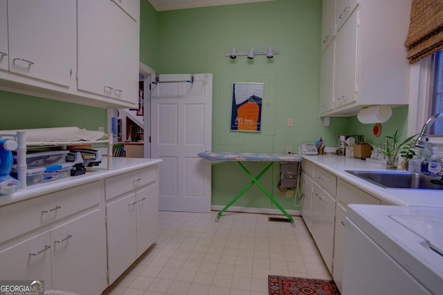 clothes washing area featuring sink and washer / dryer