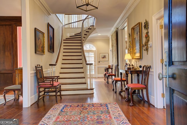 entrance foyer with ornamental molding and dark hardwood / wood-style floors