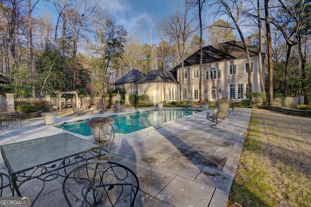 view of swimming pool featuring an outdoor structure and a patio area