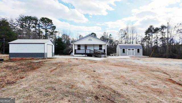 view of front of property with a garage, an outdoor structure, and a porch