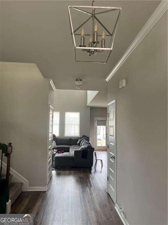 interior space featuring crown molding, dark hardwood / wood-style floors, and a chandelier