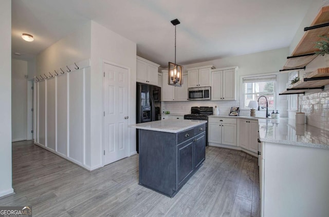 kitchen featuring white cabinetry, decorative light fixtures, black refrigerator with ice dispenser, and a kitchen island