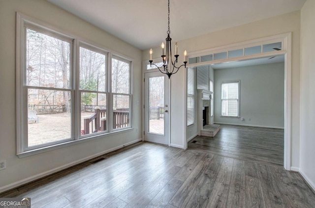 unfurnished dining area featuring dark wood-type flooring and a chandelier