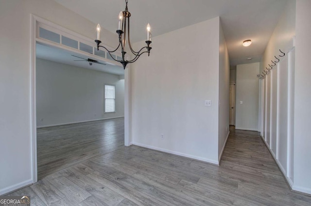 unfurnished dining area featuring a chandelier and light hardwood / wood-style flooring