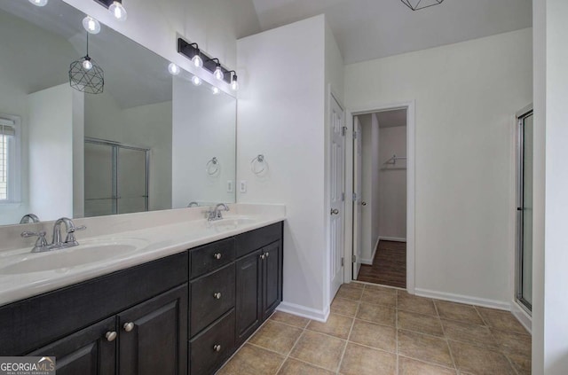 bathroom with tile patterned flooring, vanity, vaulted ceiling, and a shower with shower door