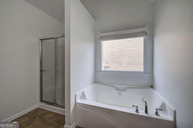 bathroom featuring lofted ceiling, tile patterned flooring, and plus walk in shower