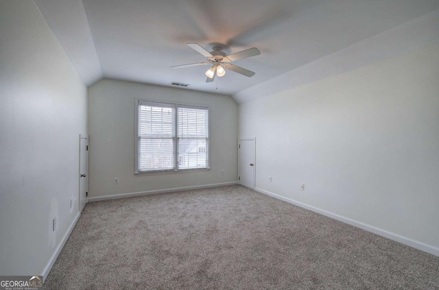 carpeted empty room with vaulted ceiling and ceiling fan