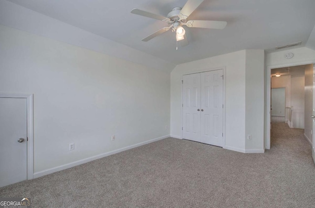 unfurnished bedroom with ceiling fan, light colored carpet, and a closet