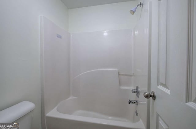 bathroom featuring shower / tub combination and toilet