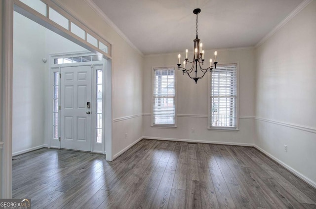 foyer entrance with an inviting chandelier, dark hardwood / wood-style floors, and crown molding