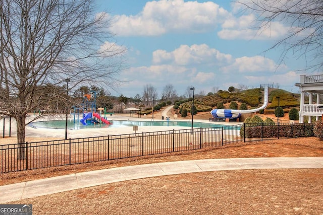 view of pool featuring a water slide and a playground