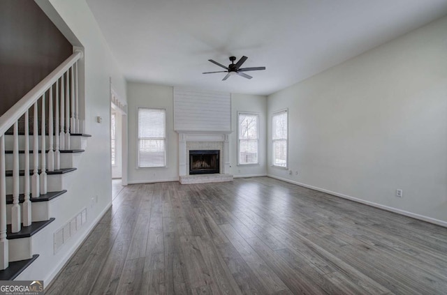 unfurnished living room featuring hardwood / wood-style flooring, a fireplace, and ceiling fan