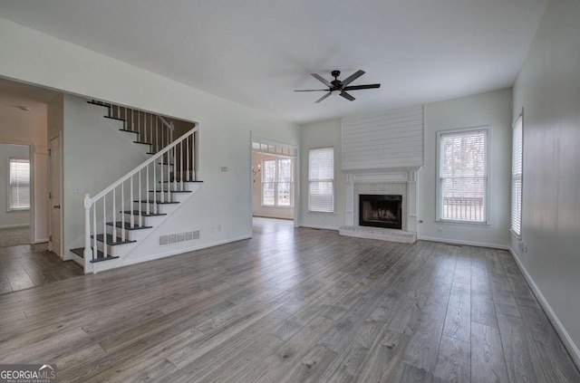 unfurnished living room featuring ceiling fan, hardwood / wood-style floors, and a wealth of natural light