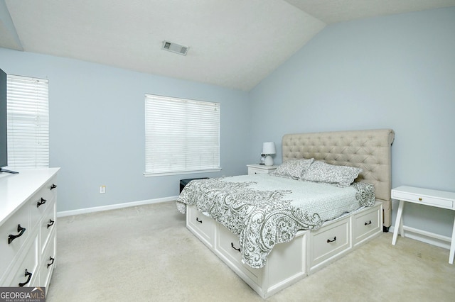 bedroom featuring lofted ceiling and light carpet