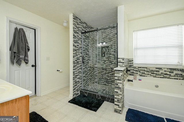 bathroom featuring vanity, shower with separate bathtub, and a textured ceiling