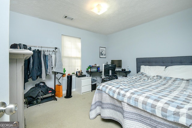 bedroom featuring light colored carpet and a textured ceiling