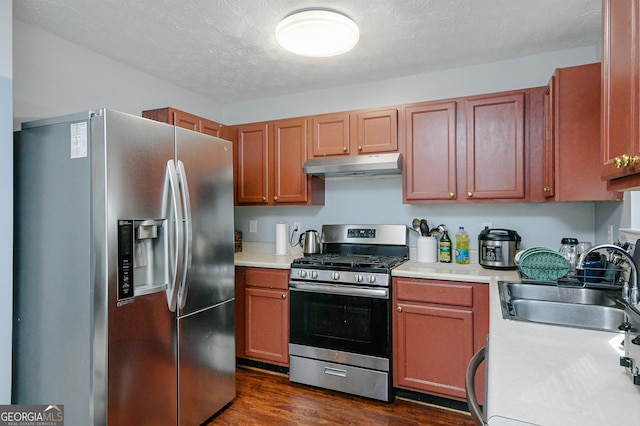 kitchen with sink, dark hardwood / wood-style floors, a textured ceiling, and appliances with stainless steel finishes